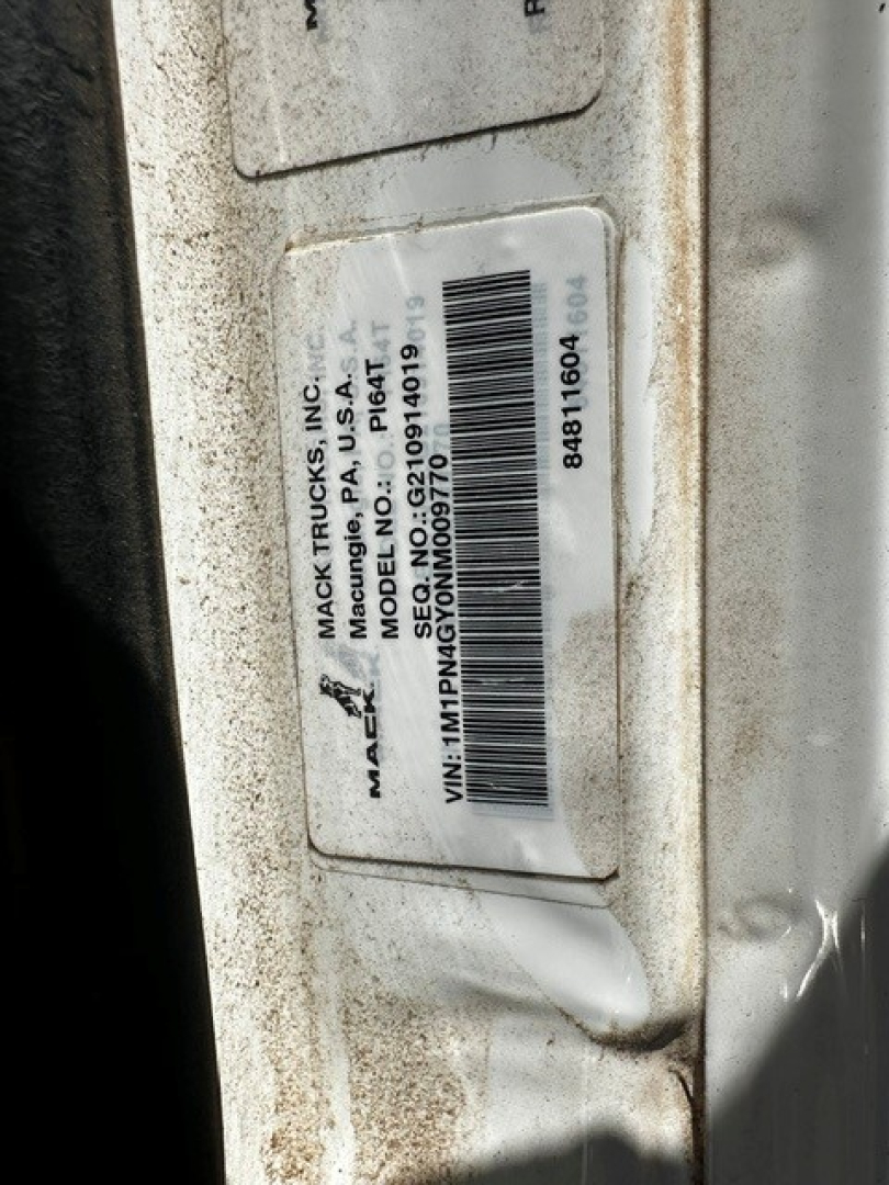 Label on Mack truck showing VIN and model information. Text visible includes 'MACK TRUCKS, INC.', 'MACK TRUCKS, INC.', 'MODEL NO P164', 'VIN: 1MNM...'? Wait exact: I can read: 'MACK TRUCKS, INC.', 'MACK TRUCKS, INC.', 'MODEL NO P164', 'MACK