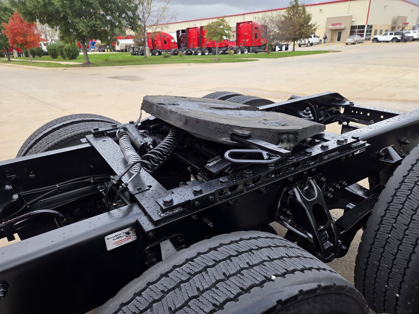 Kenworth T680 chassis and cab mounting area with exposed frame, air lines, and suspension components visible.