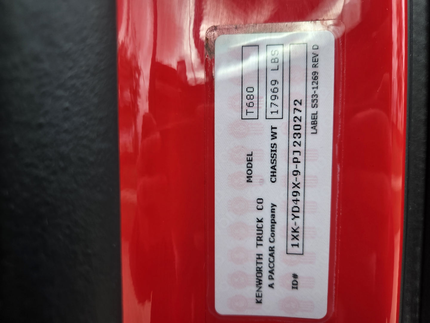 Kenworth T680 truck badge label showing model  T680 and VIN sticker on red exterior.