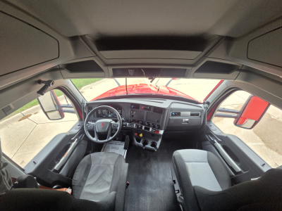 Kenworth T680 cab interior view with dashboard, steering wheel, and seats visible.