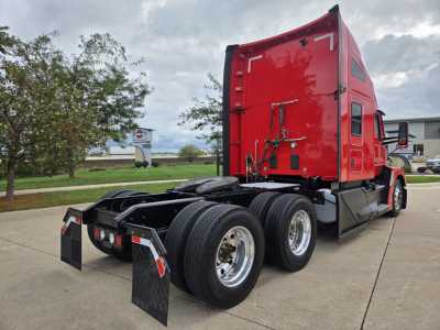 Kenworth T680 conventional sleeper rear side view showing dual rear axles and red cab with black mud flaps