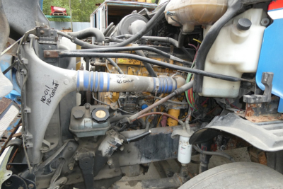 Engine bay of Freightliner CL112 showing coolant reservoir, hoses, and engine components with handwritten tape labels.