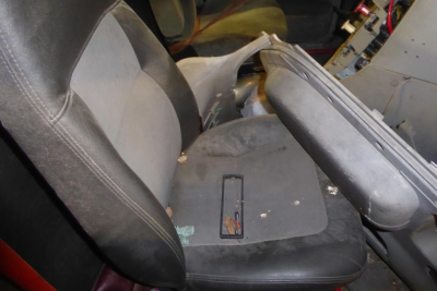 Freightliner CL112 truck interior showing seat and dashboard area with wear; passenger seat and center console visible.