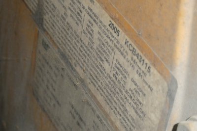Label on vehicle frame showing model year 2005 KCBA34115 and compliance text image close-up.