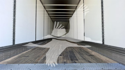 Trailer interior showing empty cargo space with wooden floor and side rails, in-service condition.