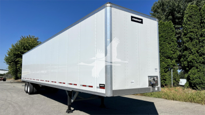 Fruehauf van trailer with clean aluminum siding and dual rear wheels, raised landing gear, and front access doors visible.