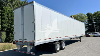 Fruehauf van trailer showing side and rear with dual rear axles and white reflective markings.