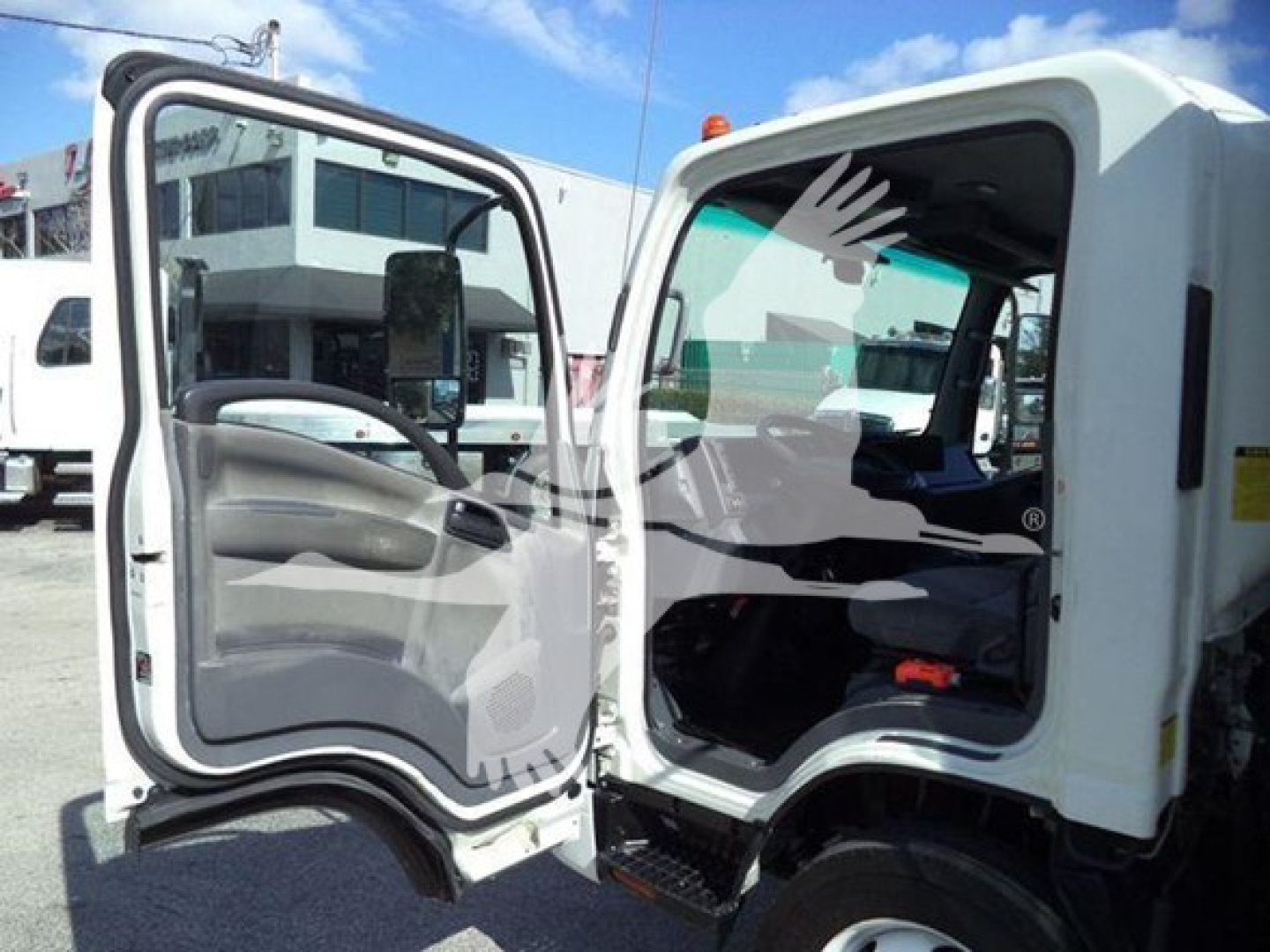 Isuzu NPR HD truck cab interior and door open showing steering wheel and driver seat.