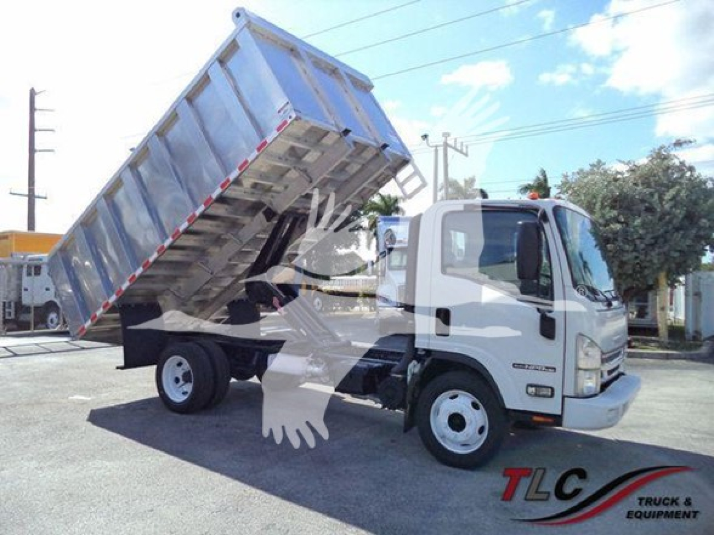 Isuzu NPR HD dump truck with bed raised showing cargo bed and hydraulic mechanism.