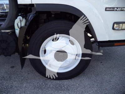 Isuzu NPR HD truck front wheel area showing wheel and fender with Isuzu NPR badge visible.