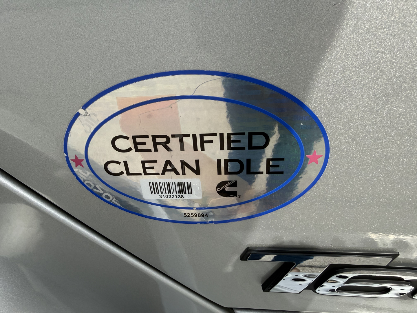 Kenworth T680 badge area with Certified Clean Idle sticker and metal surface