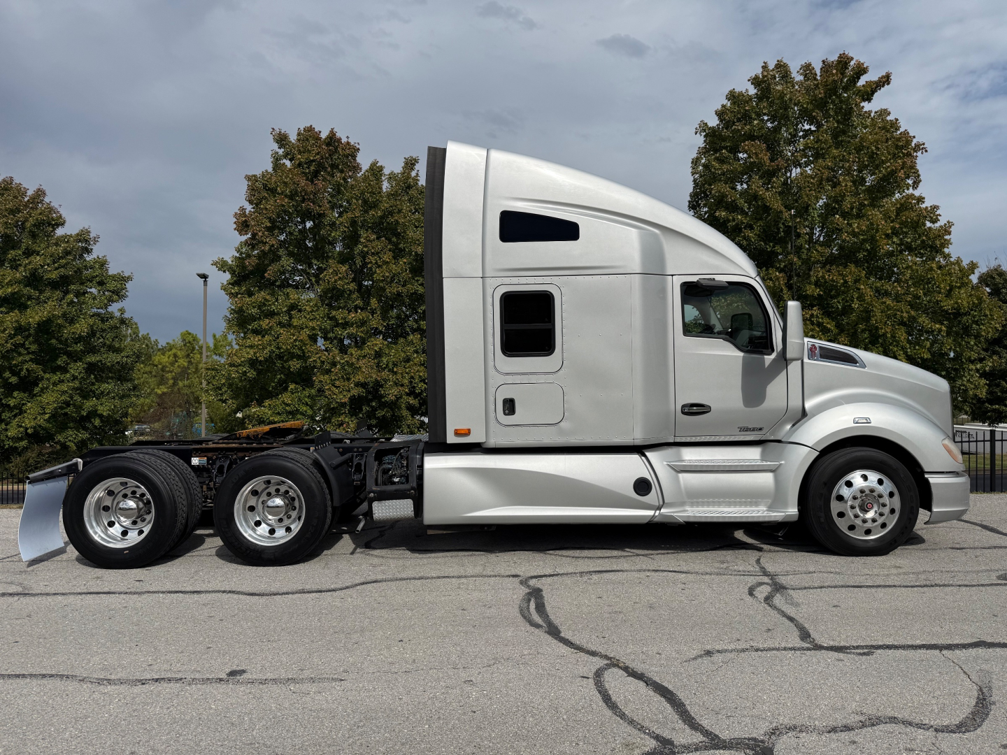 Kenworth T680 truck side view, no trailer attached, with sleeper cab and three rear axles visible.
