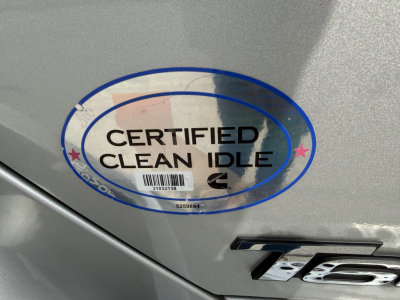 Kenworth T680 badge area with Certified Clean Idle sticker and metal surface