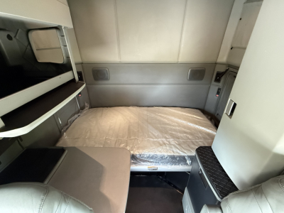 Kenworth T680 sleeper cab interior with a bed in view and storage compartments
