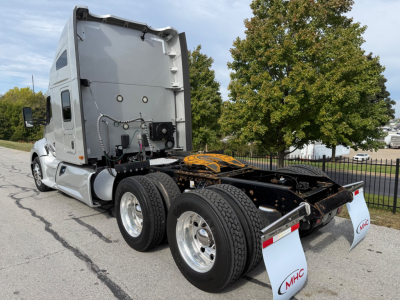 Kenworth T680 tractor rear view showing fifth wheel and dual rear axles with MHC mud flaps. Side panel text not legible.
