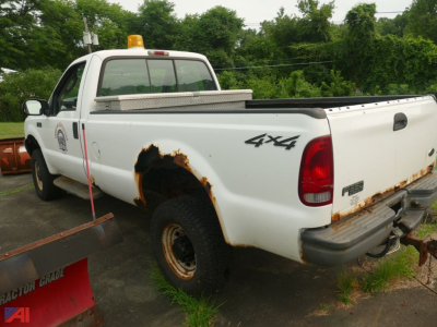 Ford F-350 Super Duty XL pickup bed with plow mount and 4x4 badge, visible rust on rear wheel well and tailgate, plow attachment at front.