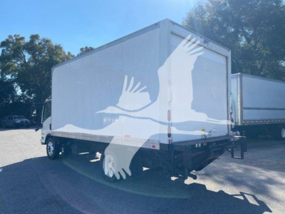 Isuzu NQR box truck seen from rear-left side. No visible labels or numbers on the truck; generic white box body with black chassis and wheels.