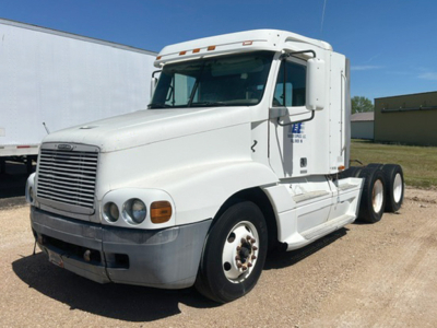 Truck cab of a white 2000 Freightliner C120 Century Class tractor, front-left view with sleeper cab, dual rear axles, chrome bumper, and Freightliner grille.