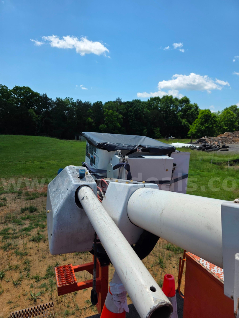 Altec TA45M boom truck arm telescoping cylinder and control cab visible in field.
