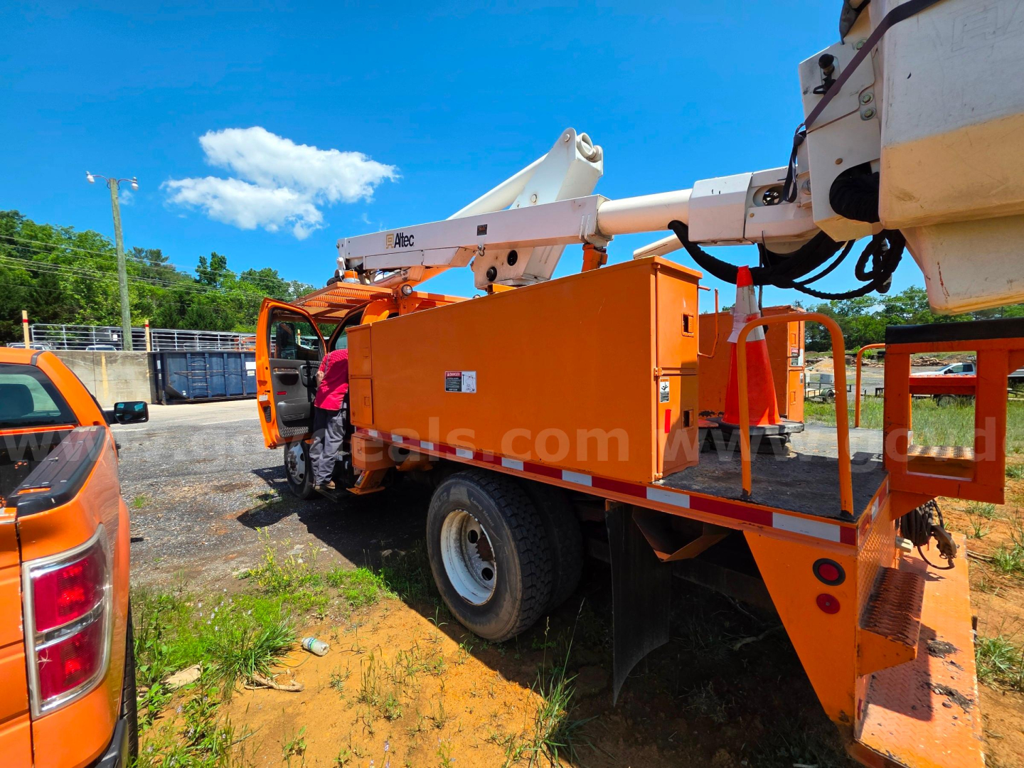Altec TA45M bucket truck with orange toolbox and white boom arm in an outdoor lot.