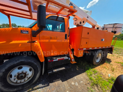 Altec TA45M bucket truck front cab and utility bed with elevated boom, orange color, GMC chassis badge, side steps, and bucket attachment.