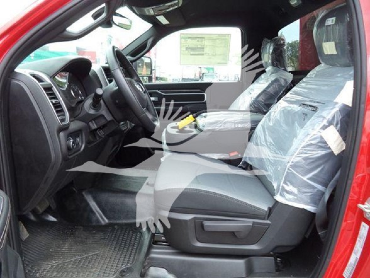 Ram 4500 SLT interior showing driver seat and front passenger seat covered in plastic, dashboard, steering wheel, and entry area visible.