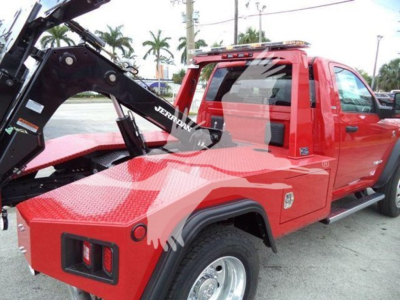 Tow truck bed area of a red Ram 4500 SLT with winch in view and hydraulic grapple attachment.