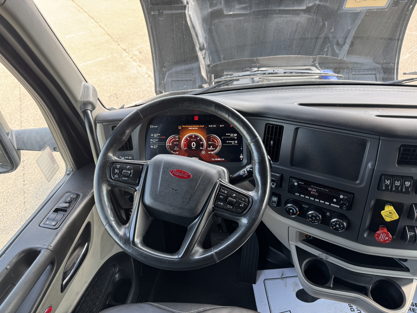 Peterbilt 579 cab interior showing steering wheel, dashboard gauges, and center console with controls.