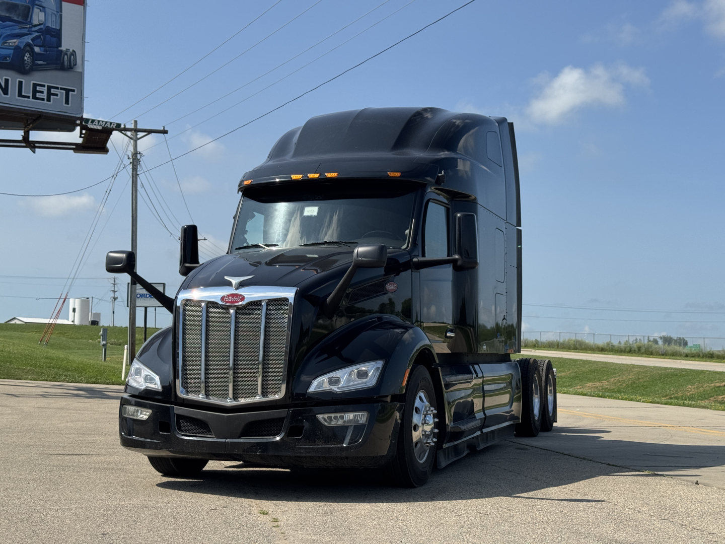Peterbilt 579 conventional sleeper truck from front-left view showing chrome grille and black cab with aerodynamic mirrors.