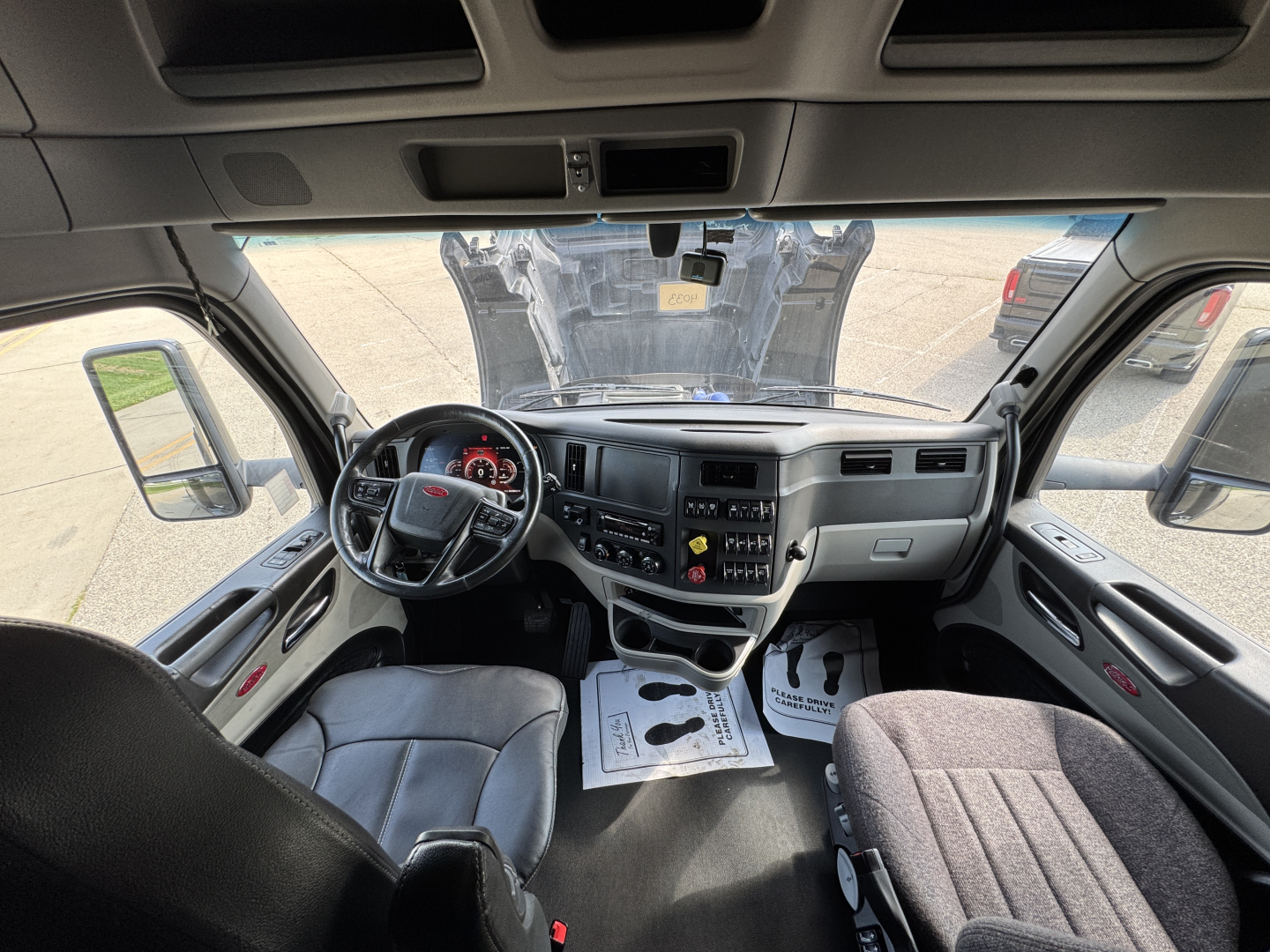 Peterbilt 579 truck interior cabin perspective showing steering wheel, dashboard, and seating view.