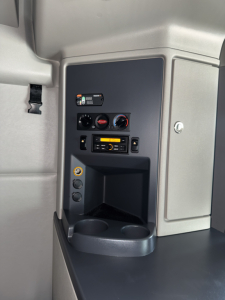 Peterbilt 579 cab interior control panel and storage area with gauges, switch panel, and cup holders.