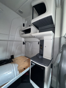 Peterbilt 579 sleeper cab interior showing overhead shelf, storage compartments, and control panels in the sleeper area.