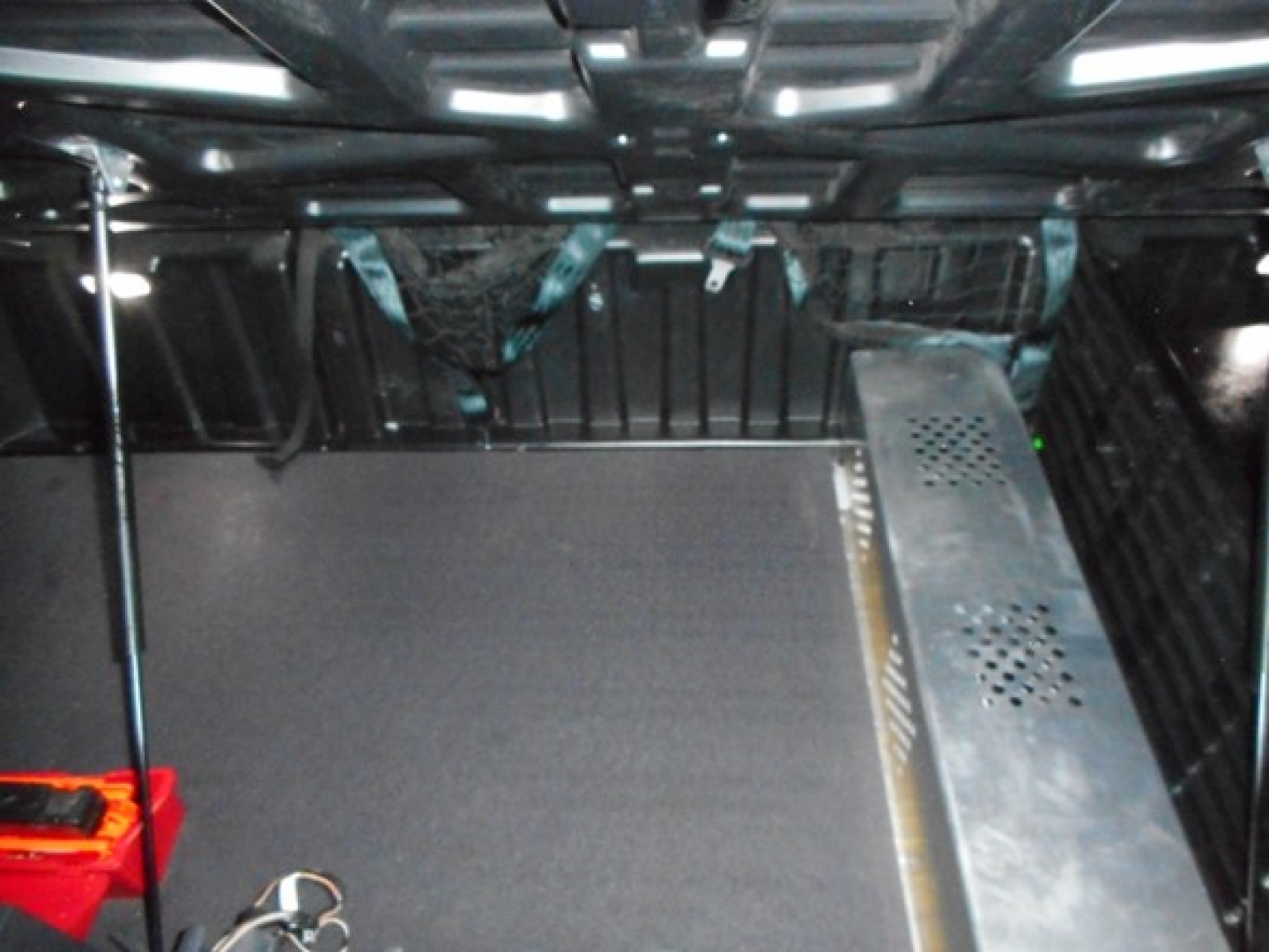 Freightliner Cascadia cab interior showing storage/under-cab area with metallic ribbed panel and a perforated metal component.