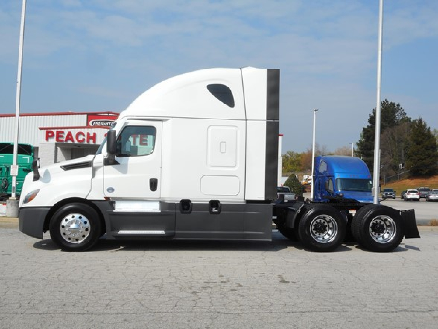 Freightliner Cascadia 126 tractor side view showing sleeper cab and chassis with aluminum fuel tanks.