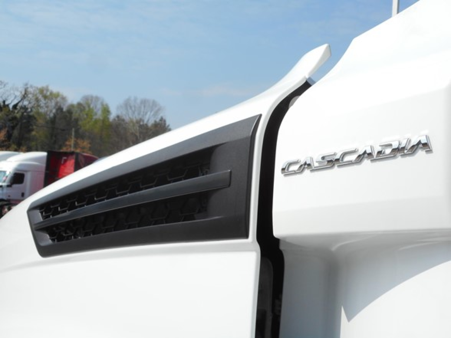 Truck cab side showing Freightliner Cascadia badge on the white exterior