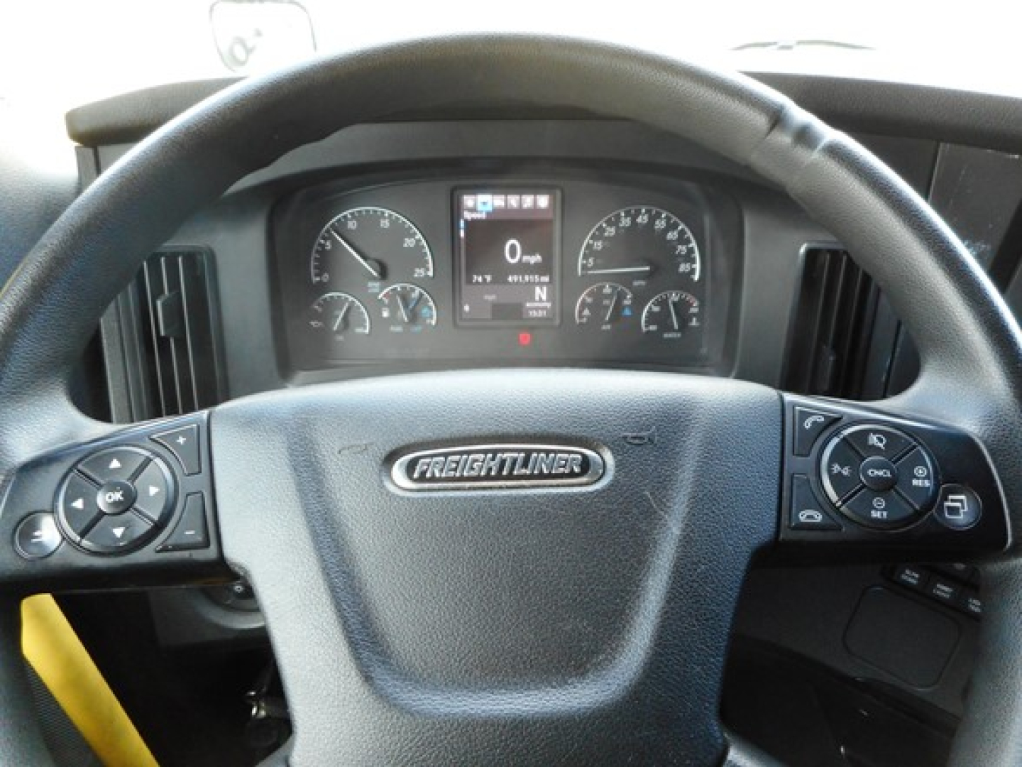Freightliner Cascadia cab interior showing instrument cluster and steering wheel with Freightliner logo.