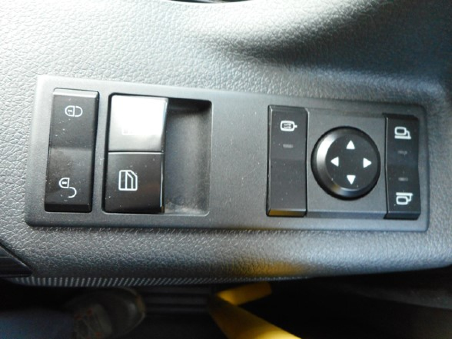 Dashboard switch panel with window controls and circular joystick on Freightliner Cascadia interior