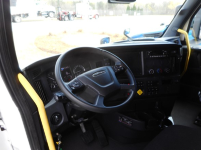Cab interior of a 2024 Freightliner Cascadia 126 truck showing steering wheel, dashboard, and infotainment screen with yellow accents.
