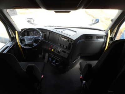Freightliner Cascadia engine bay dashboard view showing steering wheel, instrument cluster, center console, and driver seat from the cab interior.