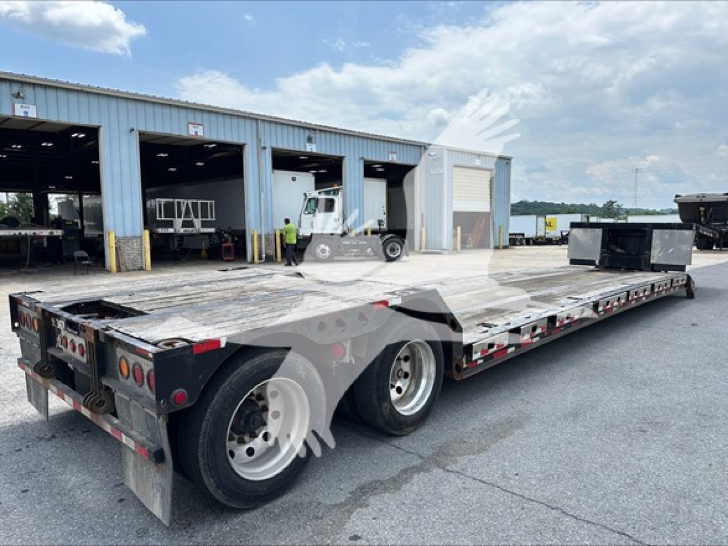 Trailer showing a low-profile flatbed with dual rear axles and gooseneck neck, XL Specialized XL80MFGA model, aluminum deck, in-service with stock 7417.
