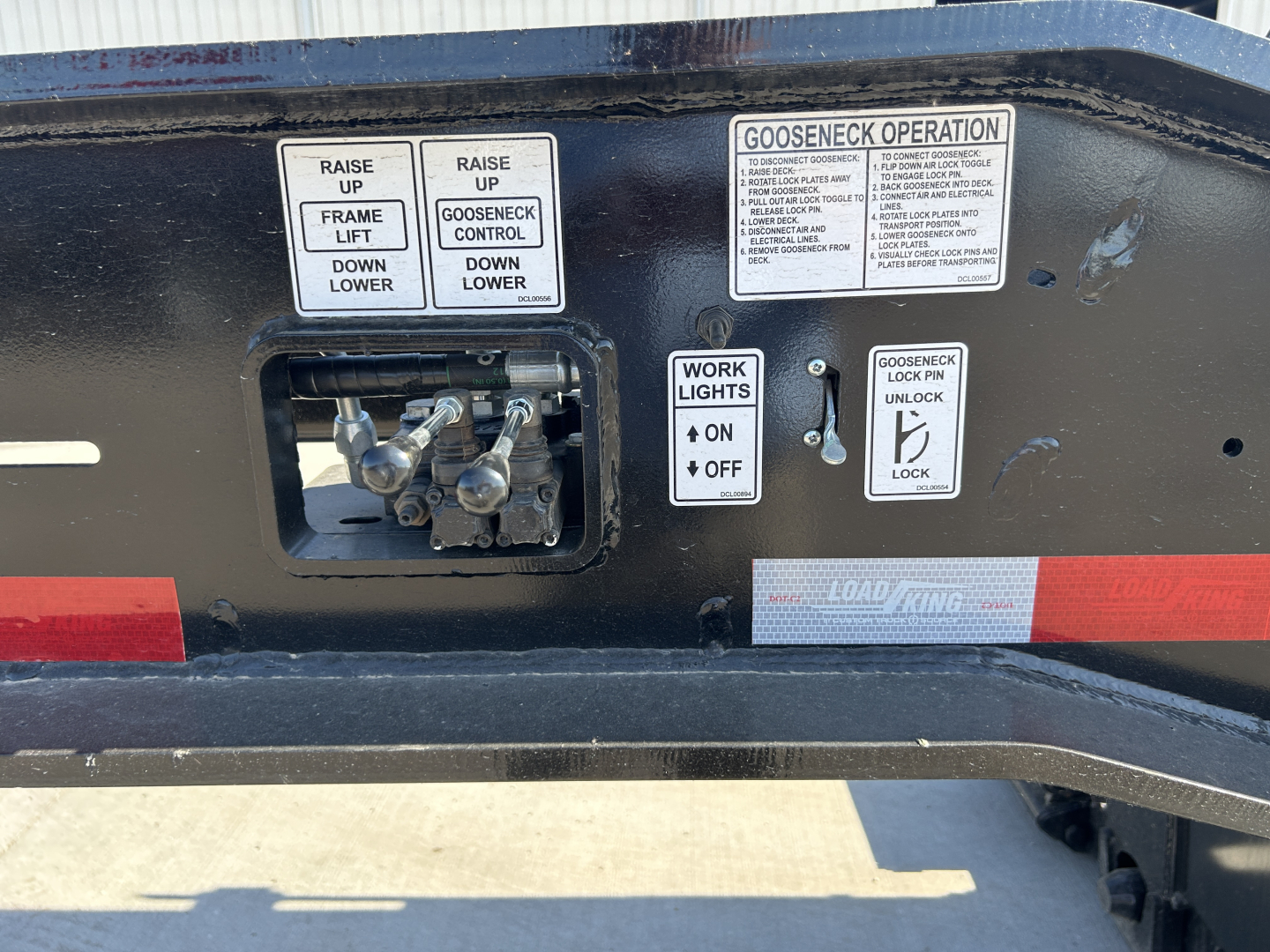 Load King trailer control panel area with gooseneck operation instructions and hydraulic controls, showing labels: Raise Up, Frame Lift, Down Lower, Gooseneck Operation, Work Lights On/Off, Unlock Lock.