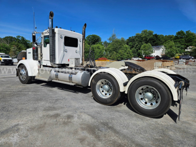 Kenworth W900L tractor shown in side view with dual rear axles and chrome fuel tanks.