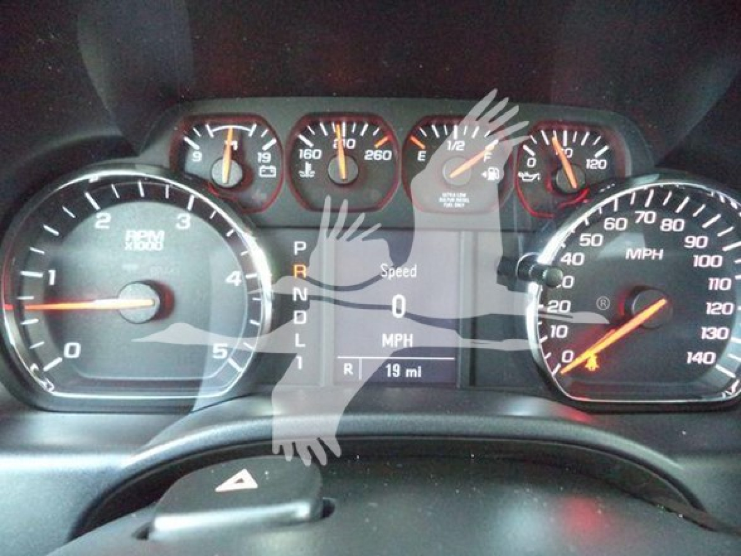 Dashboard view of a Chevrolet Silverado 6500HD showing instrument cluster with speedometer, tachometer, and digital display reading Speed 0 MPH, gear indicator P R N D L, odometer 19 mi.