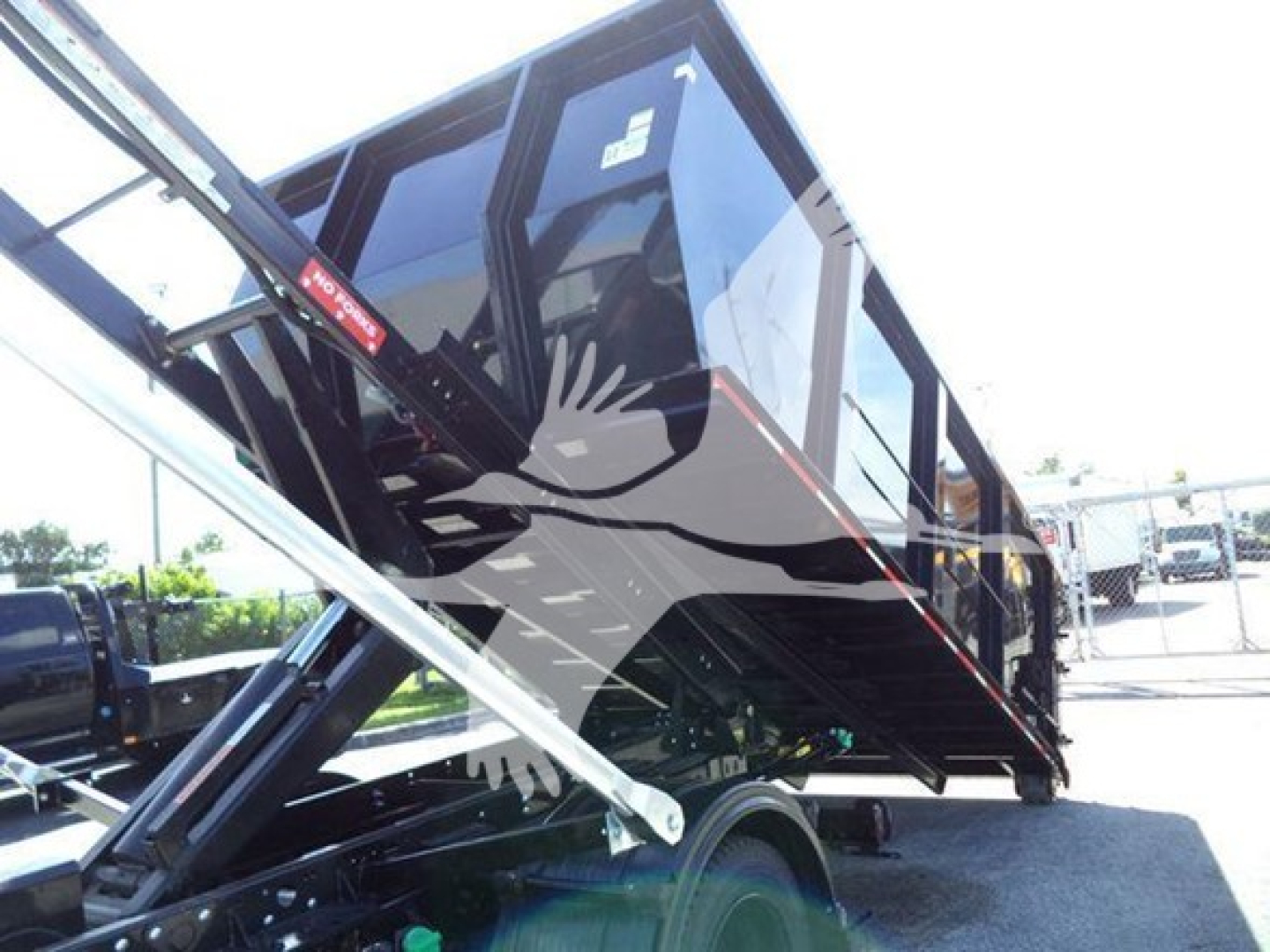 Truck dump body on a Silverado 6500HD chassis showing hydraulic lifting mechanism and raised bed with side panels.