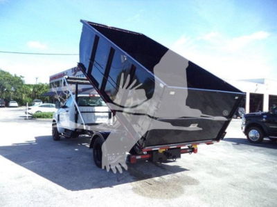 Chevrolet Silverado 6500HD dump truck in raised bed position showing rear and side view.