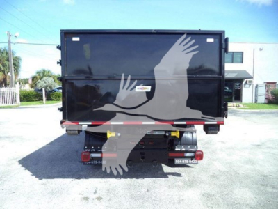 Rear view of a black roll-off truck body with a dove graphic, showing tail lights and bumper area.