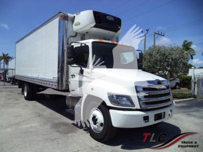 Truck rear refrigeration body with Thermo King unit on cab-front and white cargo box; cab front shows grille and headlights.