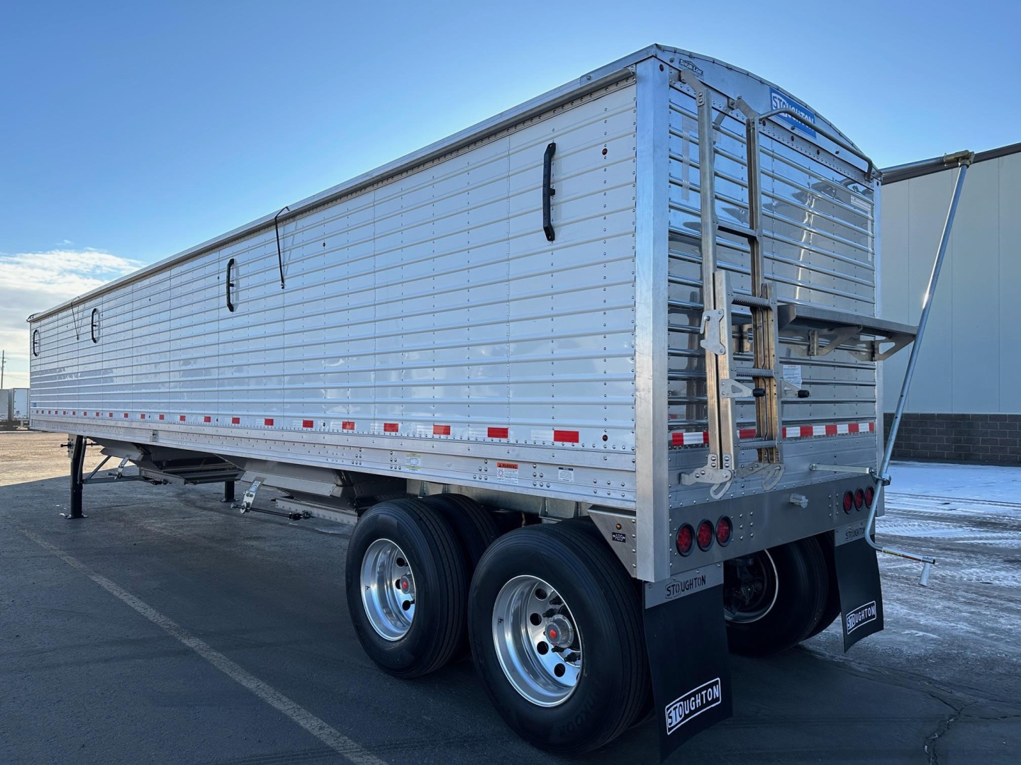 Stoughton grain trailer with air ride, 74-inch sides, aluminum body, dual rear axles, stock number 84653 visible, ramps at rear, VIN 150107446340