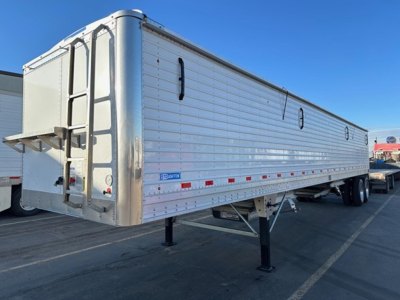 Stoughton grain trailer in-service, aluminum hopper with ladder at rear and landing gear, side doors and reflective tape, VIN 150107446340.