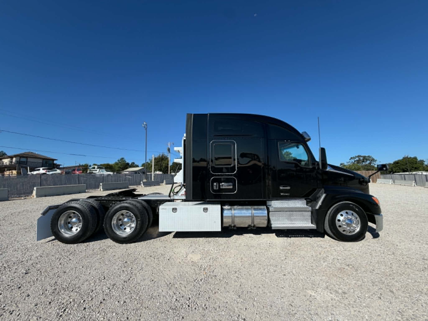 Kenworth T680 tractor cab side view showing sleeper cab, chrome fuel tanks, and dual rear axles with three wheels on the drive tandem.